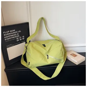 Vue détaillée du sac de voyage vert clair élégant avec fermeture éclair et bandoulière.
