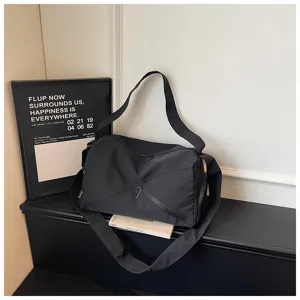 Détail de sac de voyage noir montrant un tissu durable, une sangle solide et des zips.