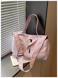 Vue de détail rapproché du sac de sport violet montrant la fermeture éclair et la sangle.