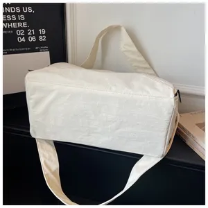 Gros-plan du sac de voyage blanc montrant le tissu durable et les détails de sangles robustes.