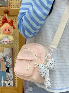 Detailed view of pink Japanese style canvas crossbody bag with cute star zipper and bow.
