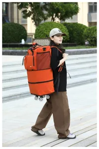 Gran mochila de viaje plegable con ruedas universales, bolsa de lona naranja duradera para exteriores.