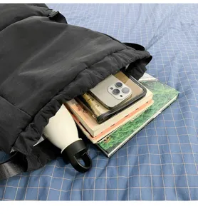 Black puffer backpack interior detail showing large capacity storage with books and water bottle.