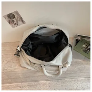 Large capacity travel duffel bag with dark lining, lace trim, and durable handles for daily gym use.