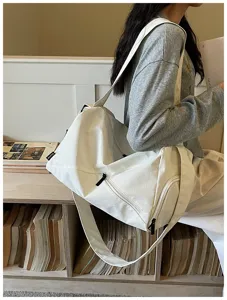 Détail de sac de voyage blanc en toile avec fermeture éclair durable et bandoulière.