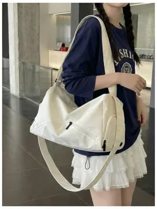 Sac de voyage bandouliere en toile blanche avec poche zippee, design spacieux et mode.