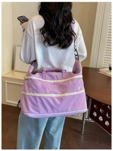 Purple travel luggage bag with white lace trim and cute pink bow embroidery for women daily use.