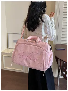 Detail view of the pink travel duffel bag with star print and embroidery for short trips.