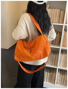 Sac de voyage de sport en toile orange pour femme avec fermeture éclair diagonale.