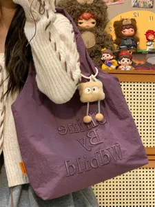 Stylish purple canvas tote bag for women, casual shoulder bag with cute plush pendant.