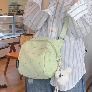 Light green star pattern crossbody bag with plush charm, casual canvas shoulder bag for women.