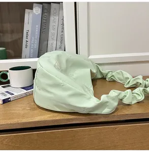 Pastel green cloud hobo bag detail with bow embroidery and trendy pleated shoulder strap.