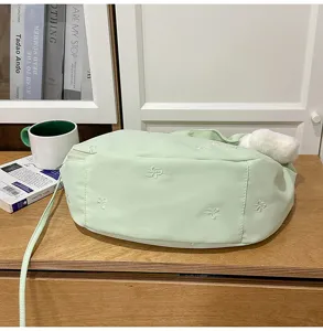 Light green cloud crossbody bag with cute bow embroidery and fluffy pendant for women.