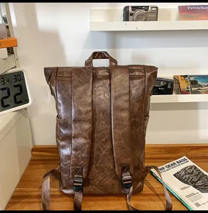 Vintage brown PU leather backpack back straps detail view with retro lifestyle setting.