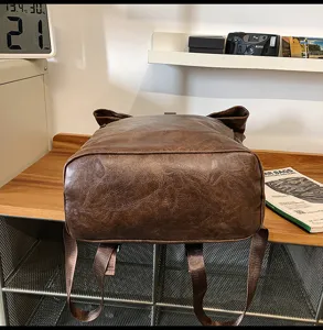 Detailed view of brown vintage leather backpack bottom and straps, casual daily travel bookbag.