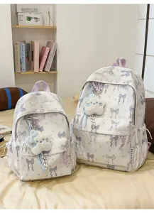 Detail view of the Japanese style backpack featuring cute bow prints and soft plush pendant in blue.