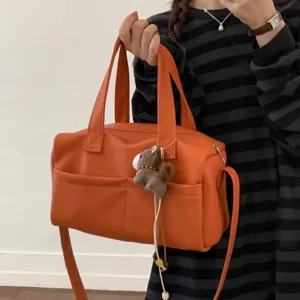 Orange leather shoulder bag detail, large capacity tote with a cute plush pendant.