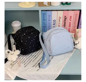 Star print crossbody bag detail view, featuring casual shoulder wear and cute plush bear charm.