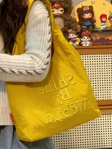 Yellow canvas tote bag for women, casual style shoulder handbag with stylish embroidery detail.