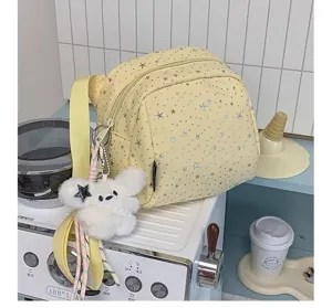 Light yellow star print crossbody bag with cute plush toy pendant, detailed lifestyle view.