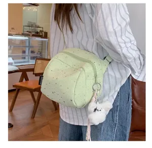 Detail shot of the light green star-patterned crossbody bag featuring a cute plush charm.