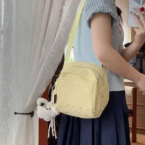 Detail view of the cute yellow star print crossbody bag with plush keychain for daily use.