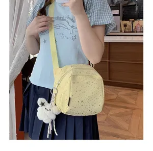 Casual yellow crossbody bag featuring star patterns and a cute plush pendant detail.
