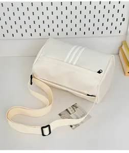 Detail view of casual canvas cylinder shoulder bag, sporty style with stripe design for travel.
