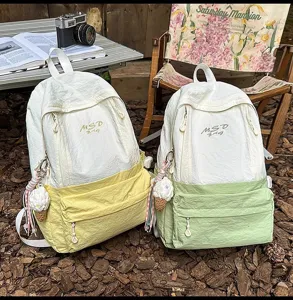 Outdoor camping style contrast color backpack detail view with front pocket and pendant
