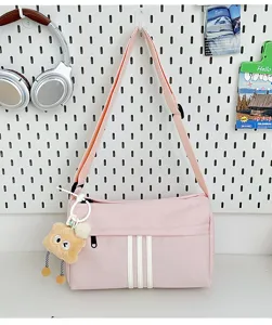 Casual pink canvas crossbody bag with cute bear pendant and triple stripes for daily travel.