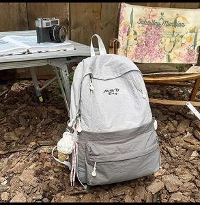 Casual outdoor travel backpack for women, large capacity daily school bookbag with cute charm.