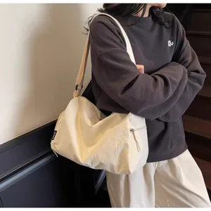 Detailed shot of casual canvas travel duffel bag in beige, showing zipper and shoulder strap.