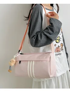 Pink casual cylinder crossbody shoulder bag with three stripes and cute bear pendant for travel.