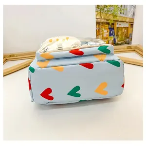 Detailed view of light blue mini backpack with colorful hearts and clear front pocket.