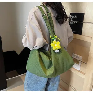 Détail de sac bandoulière en toile verte, fourre-tout décontracté avec pendentif fleur, grand.