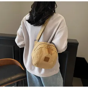 Vue détaillée du sac bandoulière en nylon décontracté au dos, forme coquillage et bretelle.