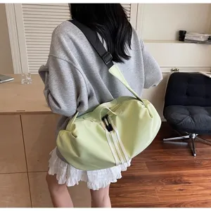 Close-up detail of light green casual crossbody duffel bag, showing design and straps.