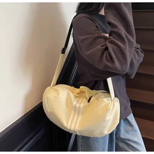 Casual yellow barrel crossbody bag with three white stripes, stylish travel and gym duffel.