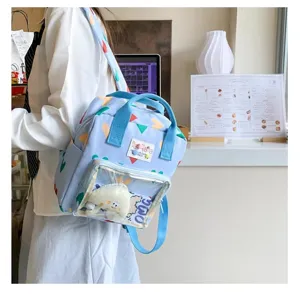 Detail view of the cute light blue backpack with clear front pocket, colorful heart pattern design.