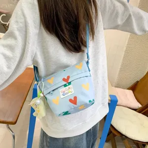 Cute canvas crossbody bag for women, featuring colorful heart print, lightweight daily shoulder bag.