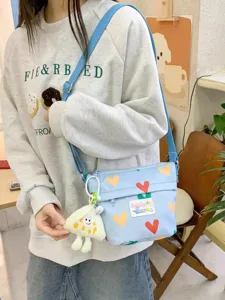 Cute canvas crossbody bag for women, summer casual small shoulder bag with sweet heart print and plush pendant.