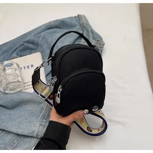 Mochila pequeña negra de nailon para mujer, bolso cruzado casual con correa estampada.