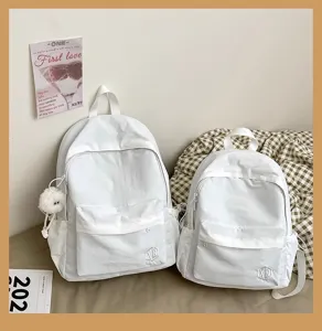 Minimalist white canvas backpack detail showcasing front pocket and clean ins style design.