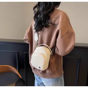 Vista detallada del pequeño bolso cruzado informal con tela duradera y herrajes metálicos.