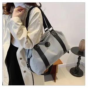 Detail view of large capacity waterproof travel duffel bag with black straps and shoulder carry.