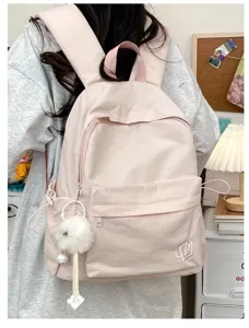 Pink casual backpack detail view, lightweight school bag with cute furry pendant and pockets.
