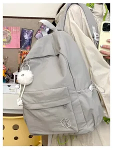 Detail shot of a minimalist solid color casual backpack, lightweight travel school bag for students.