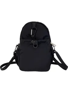 Black nylon crossbody bag with carabiner and drawstring pocket for casual daily use.