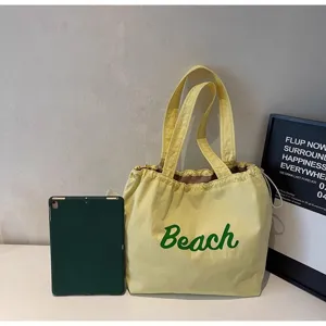 Vista detallada del bolso tote de lona amarilla con estampado Beach, gran capacidad.