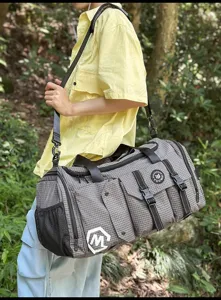 Outdoor detail view of grey plaid travel duffel gym bag with multiple pockets and straps.